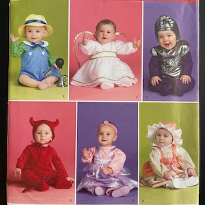 May include: Simplicity pattern for baby costumes. The image shows six babies in different costumes, including a farmer, angel, knight, devil, princess, and a baby in a bonnet. The pattern includes sizes A, XS, S, M, and L.