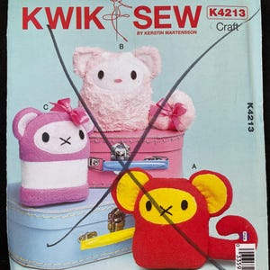 May include: A Kwik Sew K4213 sewing pattern envelope featuring illustrations of three plush animal toys. One is a fuzzy pink creature, one is a purple and white striped animal with a pink bow, and one is a red and yellow monkey-like figure.