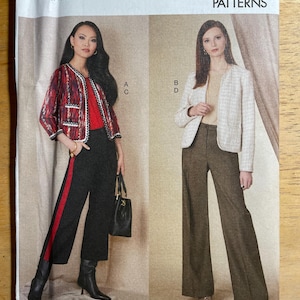May include: Vogue Patterns sewing pattern featuring two jacket and pants ensembles. One model wears a red and black jacket with black pants and a red stripe. The other model wears a cream jacket and brown pants. The pattern number is V1830.