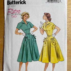 May include: A vintage Butterick sewing pattern, B6055, featuring illustrations of two women in retro dresses. The dresses are teal and yellow, with pockets and bow details. The pattern includes sizes 6-14.