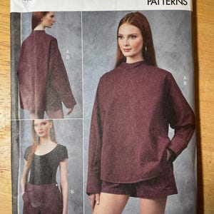May include: A Vogue Patterns sewing pattern featuring a burgundy top and shorts set. The pattern includes views of the outfit on a model, with the text "V1912" and "RACHEL COMEY" visible. The size range is YS (18-20-22-24-26).