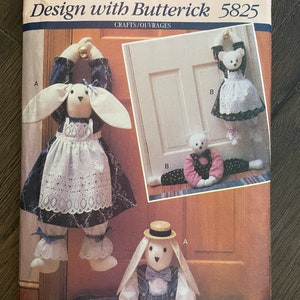 May include: A vintage sewing pattern for making bunny doorstops. The pattern includes instructions for making three different bunny designs, including a bunny with a dress, a bunny with overalls, and a bunny with a hat. The pattern is from Butterick and is number 5825.