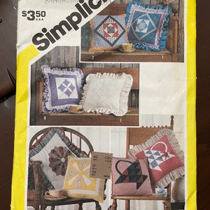 May include: Simplicity sewing pattern number 6146 for making quilted cushions. The pattern includes instructions for making five different cushions, each with a unique design. The cushions are shown on a wooden chair and a wooden bench. The pattern is priced at £3.50.