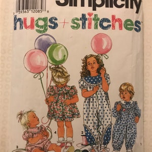 May include: Simplicity hugs + stitches sewing pattern for girls' dresses and overalls. The pattern includes four different styles: a floral print dress, a blue polka dot dress, a pink and white striped overall, and a blue floral print overall. The pattern is for sizes 1/2-2.