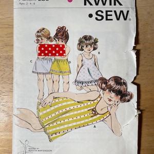 May include: A Kwik Sew pattern envelope, number 238, for ages 2-4-6. The white paper cover features illustrations of children wearing various sleeveless dresses and skirts with lace trim. Text includes Pattern 238, Kwik Sew, and Designed by Kerstin Martensson.