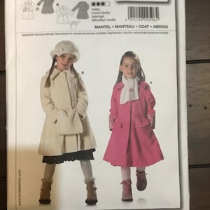 May include: Burda sewing pattern number 9596 for a child's coat. The pattern includes instructions for making a white coat with a black belt and a pink coat with a white scarf. The pattern is for sizes 104 to 140.