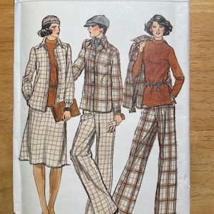 May include: Vogue Patterns sewing pattern envelope featuring illustrations of three figures in coordinated outfits. The outfits include a skirt suit, a shirt and pants set, and a top and wide-leg pants ensemble. The color palette includes brown, beige, and rust.