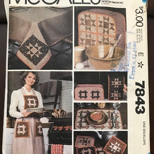 May include: Sewing pattern for a quilt set with a star design. The pattern includes instructions for making a table runner, placemats, and an oven mitt. The pattern is from McCall's and is number 7843.
