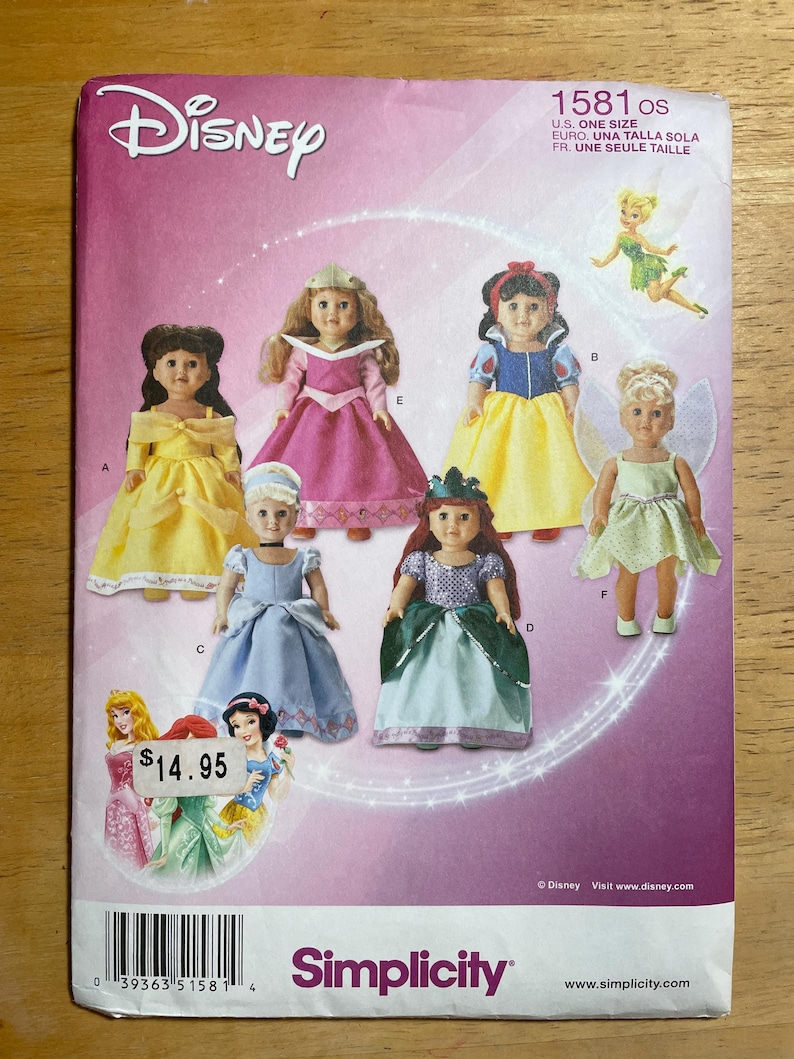 May include: A Simplicity sewing pattern envelope for Disney character doll outfits, numbered 1581. The front displays illustrations of six dolls wearing various costumes, including yellow, pink, blue, and green dresses, with the Disney logo at the top.