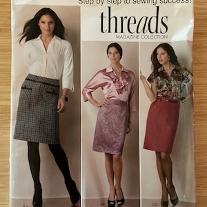 May include: Simplicity Threads Magazine Collection sewing pattern number 2564 for sizes US 16, 18, 20, 22, 24, EUR 42-50, FR 44-52. The pattern features three women wearing different skirts and tops. The text "Step by step to sewing success!" is printed on the pattern.