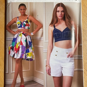 May include: Vogue Patterns sewing pattern featuring two women's outfits. One outfit includes a colorful crop top and skirt, the other a denim-look crop top and white shorts. The pattern number is V1893, size A5 (6-8-10-12-14).