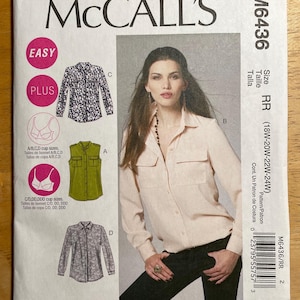 May include: McCall's sewing pattern M6436. The pattern features illustrations of various shirt styles, including a long-sleeved button-down and a sleeveless top. The package includes size options and cup sizes. The model in the image is wearing a light pink button-down shirt.