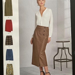 May include: Simplicity sewing pattern 8699 for skirts, sizes 6-14. The pattern includes various skirt styles, such as a wrap skirt and a denim skirt. The image shows a woman wearing a brown wrap skirt. The pattern is designed and printed in the USA.