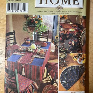 May include: Simplicity Home pattern showing table setting designs. The cover displays a dining table with a red and blue tablecloth, matching chair pads, and place mats. The pattern includes instructions for table runners and a silverware caddy.