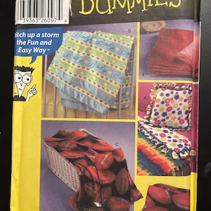 May include: A sewing pattern titled "Sewing Patterns For Dummies." The pattern features images of baby blankets, a pillow, and a blanket with football designs. The pattern is from Wrights.