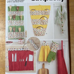 May include: Simplicity sewing pattern S9659. The pattern includes instructions for making kitchen accessories such as a knife roll, pot holders, an apron, and utensil holders. The pattern features the text "easy-to-sew".