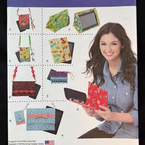 May include: Simplicity pattern 1339 OS featuring various bag and case designs. The pattern includes instructions for creating small purses, tablet cases, and crossbody bags. The designs showcase a variety of fabrics and embellishments, with a woman holding a red case.