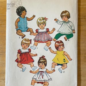 May include: A sewing pattern for making doll clothes. The pattern is for a 15-17 inch doll and includes five different outfits: a red and white gingham dress, a yellow dress with a flower, a white dress with a red bow, a green and white polka dot top with green pants, and a blue and white gingham onesie.