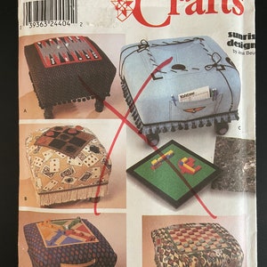 May include: A Simplicity Crafts pattern for making four different game-themed footstools. The footstools are covered in fabric with various game-themed designs, including a checkerboard, playing cards, and a game board. The pattern is titled "Sunrise Design" by Jana Beu.