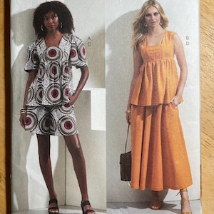 May include: Vogue Patterns sewing pattern featuring two different outfits. One outfit is a matching top and shorts set with a circular pattern in red, white, and black. The other is an orange sleeveless top and skirt.