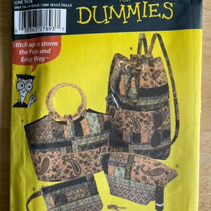 May include: A Simplicity 5076 sewing pattern envelope for quilted bags, featuring a bright yellow background with black text. The cover displays illustrations of four different bag styles with a brown and black paisley and patchwork fabric design.