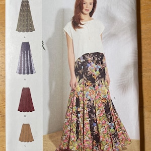 May include: Simplicity sewing pattern S8923 H5 featuring a woman wearing a floral skirt. The pattern includes multiple skirt designs. The package has the text "SIZE U.S. 6-14" and "SINCE 1927".