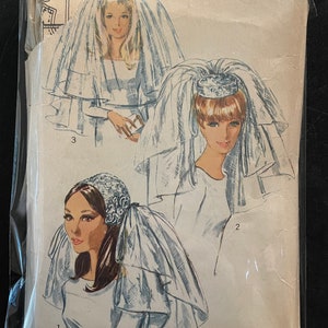 May include: Vintage Simplicity sewing pattern for a bridal veil. The pattern shows three different styles of veils, each with a different headpiece. The pattern number is 775.
