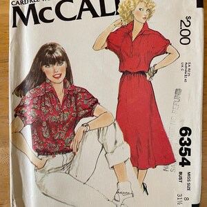 May include: A sewing pattern for a red dress and a red and white patterned blouse. The pattern is from McCall's and is size 8, bust 31 1/2 inches. The pattern number is 6354.