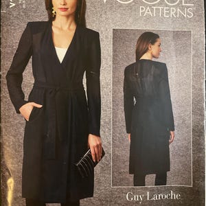 May include: Vogue Patterns sewing pattern featuring a Guy Laroche design. The pattern includes a long black coat with a wrap-style front, a belt, and long sleeves. The pattern also shows a woman wearing the coat.