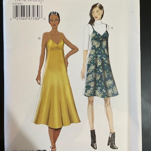 May include: A sewing pattern from Very Easy Vogue, V9278, featuring illustrations of two dresses. One is a yellow satin midi dress, and the other is a floral print slip dress. The pattern includes sizes 14-22 and is designed for A, B, C, and D cup sizes.