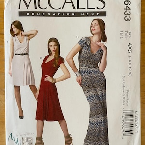 May include: McCall's Generation Next sewing pattern for a dress, pattern number M6433, size AX5 (4-6-8-10-12). The pattern shows three different styles of dresses: a white dress with a V-neck and a belt, a red dress with a V-neck and short sleeves, and a blue and white patterned dress with a V-neck and long sleeves.