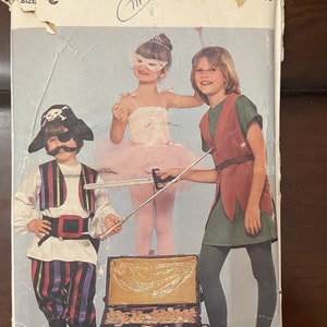 May include: A vintage sewing pattern featuring three children dressed in costumes. The girl on the left is wearing a pink ballerina costume, the girl in the middle is wearing a green and brown Robin Hood costume, and the boy on the right is wearing a black and red pirate costume. The pattern is titled "Butterick" and includes a chest of gold coins.