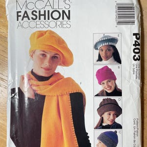 May include: McCall's Fashion Accessories pattern P403. The image shows a woman wearing a yellow beret and scarf. The pattern includes instructions for making various hats, including a pink beanie and a blue and gray hat.