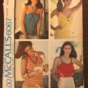 May include: A sewing pattern for a set of tops for women. The pattern includes four different styles of tops, including a halter top, a tank top, and a sleeveless top. The pattern is from McCall's and is number 6067.