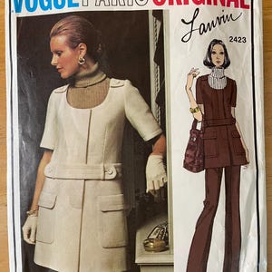 May include: Vogue Paris Original Lanvin sewing pattern number 2423. The pattern features a white dress with a brown belt and a brown pantsuit.
