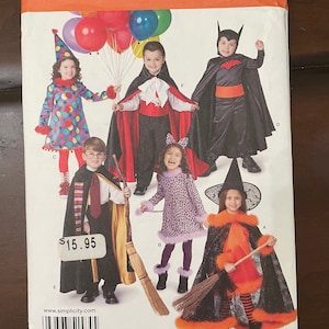 May include: Simplicity sewing pattern number 1584A for children's Halloween costumes. The pattern includes six different costumes: a witch, a cat, a vampire, a wizard, a clown, and a bat. The pattern is for sizes 3-8.