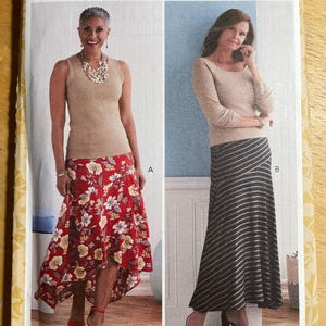 May include: A Butterick sewing pattern envelope featuring two women modeling clothing. One woman wears a tan tank top and a red floral skirt. The other wears a tan long-sleeve top and a black and white striped skirt. The pattern number is B6818.