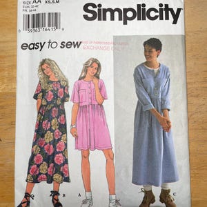 Peut inclure: Un patron de couture Simplicity, numéro 9340, avec des illustrations de trois modèles de robes. Le paquet contient le texte "easy to sew". La taille est AA XS, S, M.