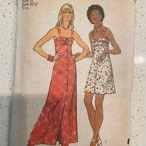 May include: Simplicity sewing pattern number 5618 for a dress. The pattern is for size 10, bust 32 1/2 inches, and is for misses. The pattern shows two models wearing the dress. One model is wearing a red and white patterned dress with a long skirt and a button-up front. The other model is wearing a shorter dress with a floral print. The pattern is priced at £1.00 in the UK and Canada.