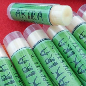 May include: A close-up of several green and white lip balm tubes with the text "Happy Birthday" and "Akira" on the labels.