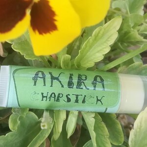 May include: A green and white tube of lip balm with the text "AKIRA CHAPSTICK" on the label.