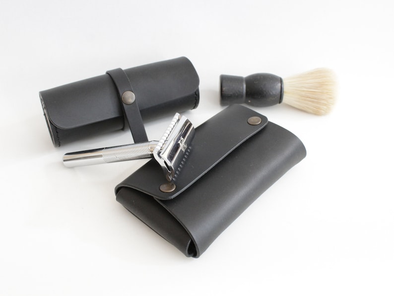 May include: A black leather shaving kit with a safety razor, a shaving brush, and a separate pouch for the razor.