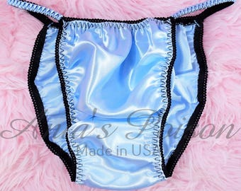 May include: Light blue satin lingerie with black trim. The lingerie has a ruffled edge and is made in the USA.