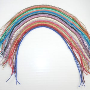 May include: A rainbow assortment of 20 braided leather cords, each approximately 30 inches long. The cords are arranged in a semi-circle, with the ends of the cords fanned out.