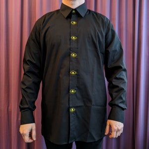 May include: A black long-sleeved button-down shirt with yellow eye buttons.