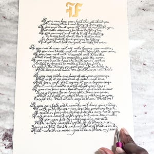 May include: A cream-colored paper sheet featuring the poem If by Rudyard Kipling written in black calligraphy. At the top, a gold-colored FF monogram is printed. The text is written in a cursive script style, and the paper is rectangular.