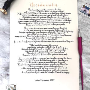 Puede incluir: Una hoja de papel color crema con el poema Desiderata de Max Ehrmann en caligraf&iacute;a negra, acompa&ntilde;ada de un sello de lacre negro, una pluma caligr&aacute;fica magenta y dos sellos postales, uno con un b&uacute;ho y otro con un faro.