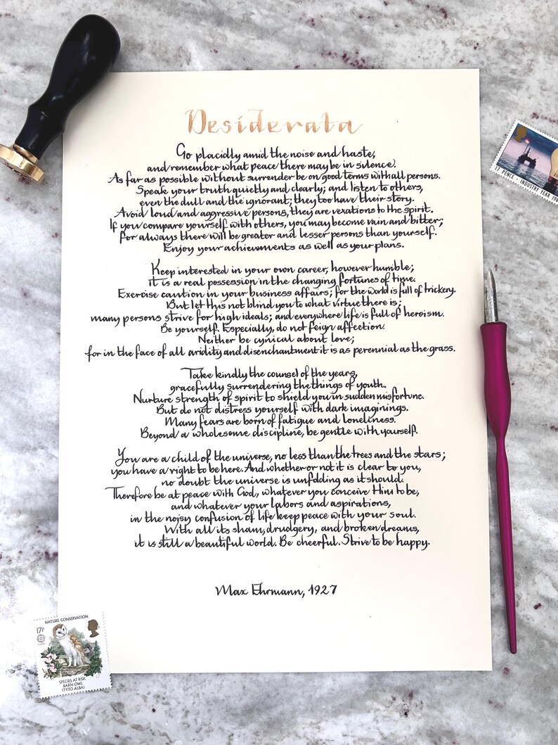 Puede incluir: Una hoja de papel color crema con el poema Desiderata de Max Ehrmann en caligraf&iacute;a negra, acompa&ntilde;ada de un sello de lacre negro, una pluma caligr&aacute;fica magenta y dos sellos postales, uno con un b&uacute;ho y otro con un faro.