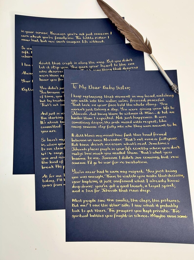 Puede incluir: Tres hojas de papel azul oscuro con texto escrito a mano en tinta dorada, incluyendo el encabezado To My Dear Baby Sister, acompa&ntilde;adas de una pluma de ave marr&oacute;n con punta de metal plateado colocada en diagonal sobre los papeles.