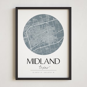 May include: A black framed print with a gray circle map of Midland, Texas. The text "MIDLAND texas 31.9973° N - 102.0779° W" is printed below the map.